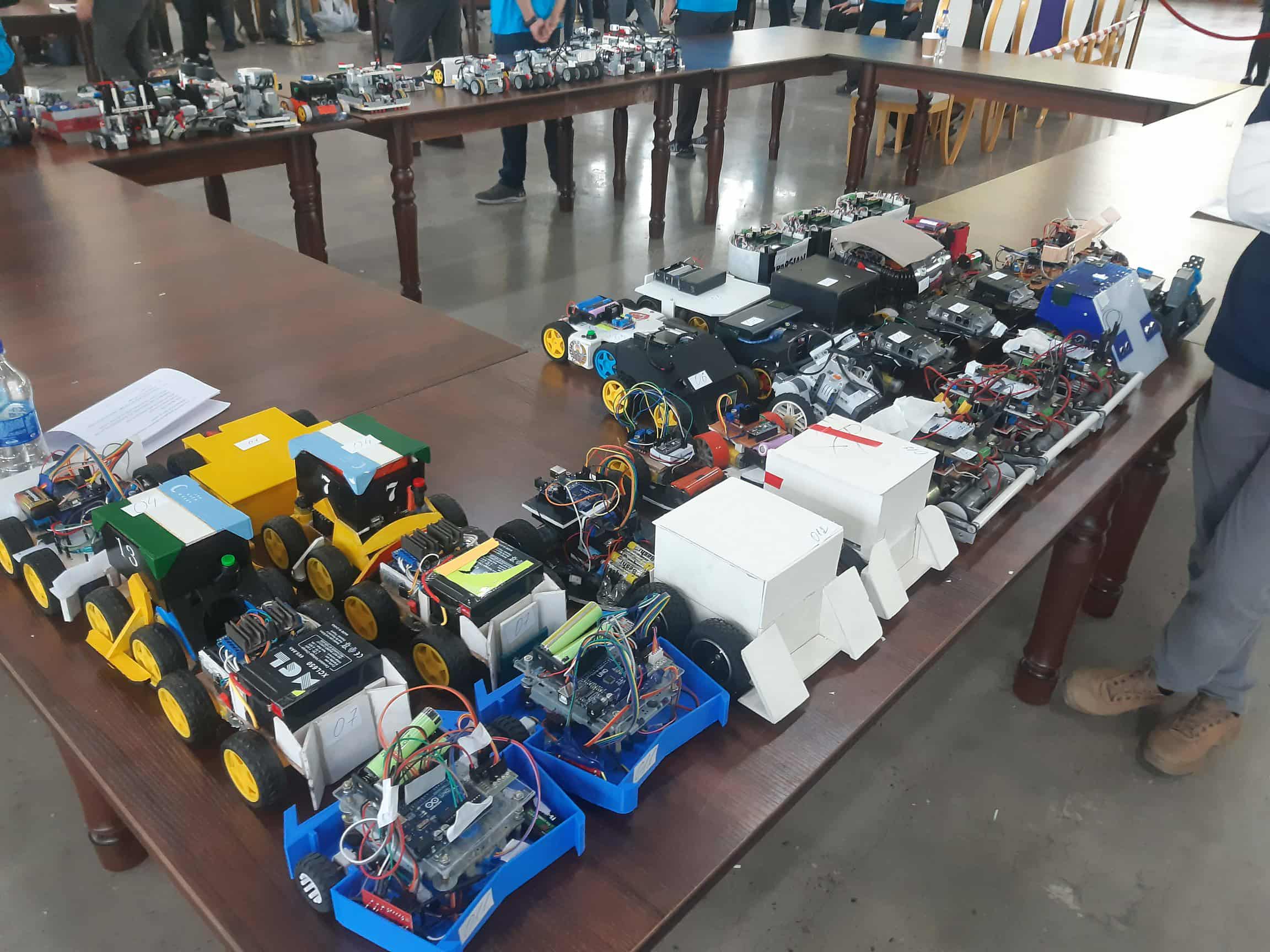 Robots arranged on a table at a robotics event